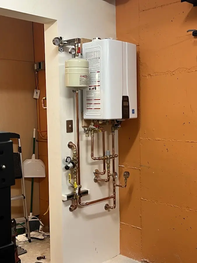 Plumbing technician inspecting water heater connections in Gateway